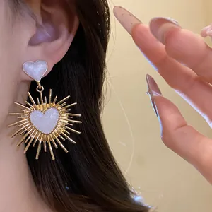 Élégantes boucles d'oreilles vintage en forme de cœur doré avec design soleil scintillant
