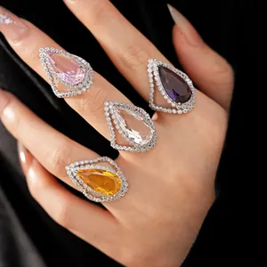 Detailed view of four colorful teardrop cubic zirconia rings with micro-pave halo