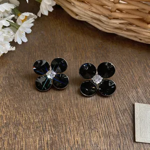 Elegant black faceted flower stud earrings with sparkling crystal center detail.