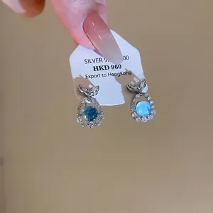 Exquisite sea blue zircon fish-shaped stud earrings in silver with shimmering accents.
