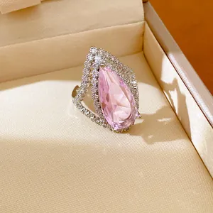 Detailed macro view of a pink teardrop zircon ring with an elegant crystal halo design
