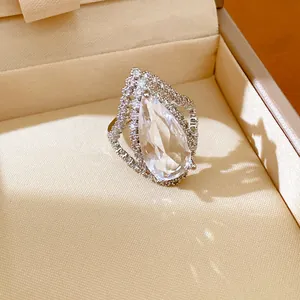 Close-up detailed view of an exquisite pear-shaped zircon open ring in a beige jewelry box