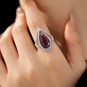 Close-up of elegant pear-shaped purple zircon ring with sparkling double halo