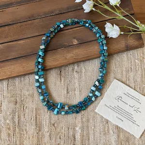 Detailed macro shot of a double-layered teal square shell bead necklace for vacation