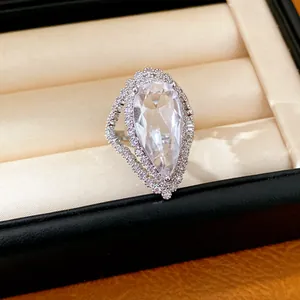 Close-up detail of a pear-cut zircon ring with an elegant halo setting in a box