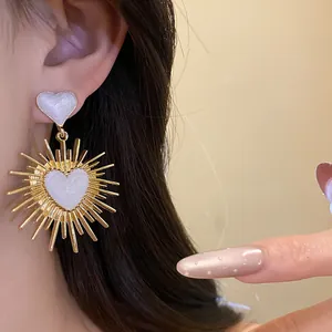 Gros plan de boucles d'oreilles vintage en forme de cœur avec un motif sunburst