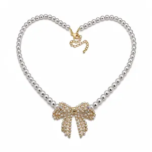 Elegante 18k vergoldete Perlenkette mit einem funkelnden Zirkonia-Schleifenanhänger.