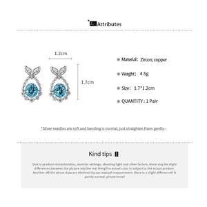 Close-up detail of blue zircon fishtail stud earrings with dimensions and material.