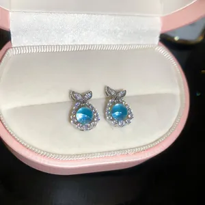 Exquisite detail of whale tail stud earrings with sea blue stones and zircons in box
