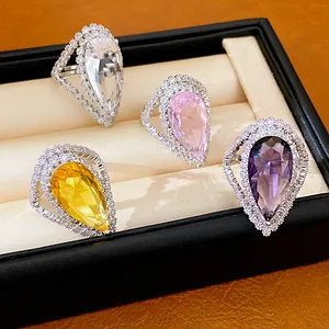 Close-up of elegant palace style zircon water drop rings in varied colors within a box.