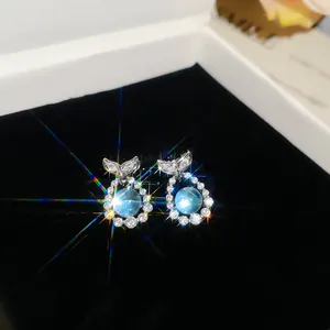 Macro detail view of elegant blue zircon fish tail earrings displayed on black velvet