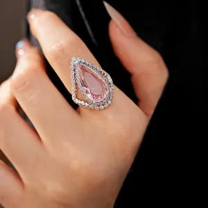 Close-up detail of a luxury pear-shaped pink cubic zirconia ring on a finger