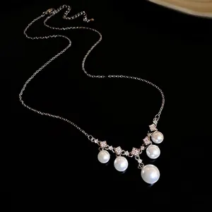 Collier élégant avec zircons carrés et cinq perles pendantes sur fond sombre