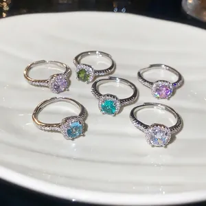 Exquisite set of colorful round zircon rings with adjustable silver bands on a white plate