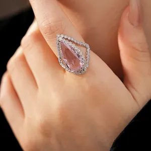 Exquisite close-up view of a pink teardrop zircon ring with sparkling double halo stones