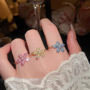 Elegante set di tre anelli a fiore in zircone colorato indossati su una mano femminile