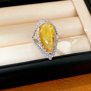 Close-up of luxury pear-cut yellow zircon ring with sparkling halo in a jewelry box