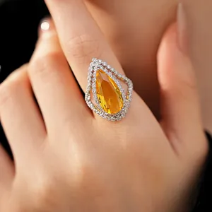 Detailed macro view of a luxurious pear-shaped yellow zircon ring with a double halo