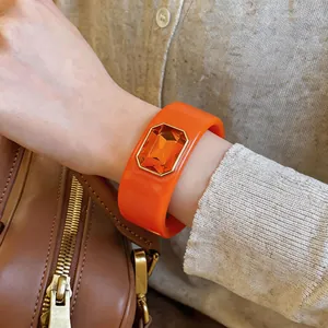 Gedetailleerde weergave van een dikke oranje armband met een grote oranje edelsteen