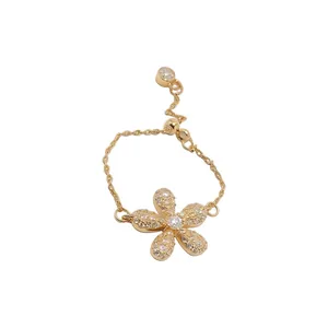 Anello a fiore in oro decorato con zirconi chiari e un design a catena regolabile