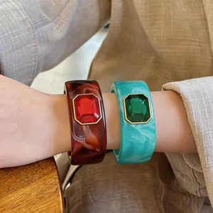 Close-up van luxe hars armbanden met grote rode en groene vierkante edelstenen