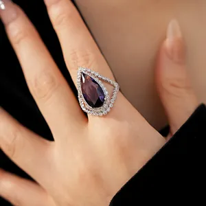 Close-up of exquisite pear-cut purple zircon ring with halo setting for elegant look.