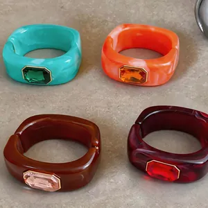 Detailweergave van vierkante hars armbanden met kleurrijke kristallen in vier tinten