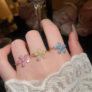 Primo piano di anelli a fiore in zircone colorato con design a catena sottile da donna.