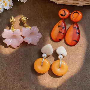 Vintage French style resin earrings featuring flower and heart shapes in warm orange and pink