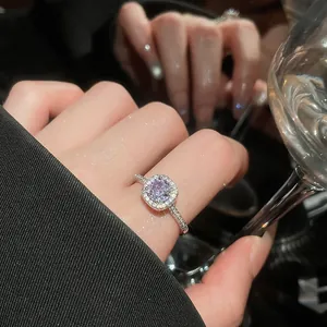 Close-up of elegant silver ring with lavender round zircon in halo setting.