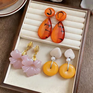 Selection of French vintage resin flower and geometric dangle earrings in a jewelry tray