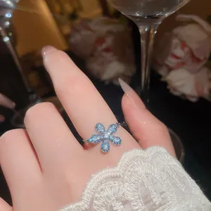Dettaglio ravvicinato di un anello in argento con un fiore a cinque petali e zirconi