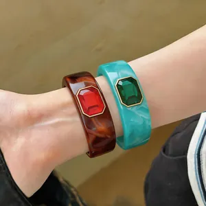 Gedetailleerd overzicht van luxe rode en groene kristallen gezet op hars armbanden