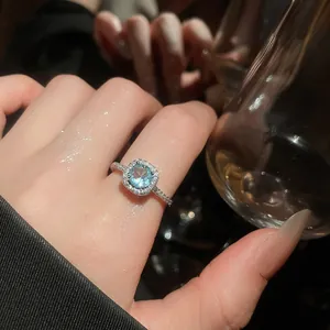 Detailed close-up of an elegant adjustable ring with a light blue zircon stone.