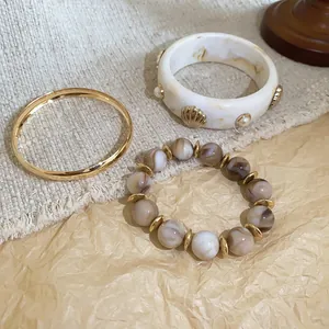 Detailed view of the vintage three-piece bracelet set with resin and golden metallic finish