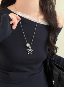 Gros plan d'un collier fleur argenté avec perle de style coréen sur un modèle