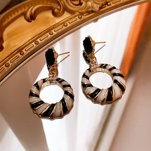 Vintage black and white striped hoop earrings with black gemstone detail on a mirror.