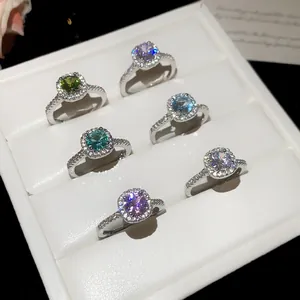 Detailed showcase of luxury colorful zircon halo rings set in an elegant white jewelry box