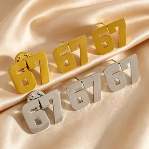 Primo piano di borchie e spille numero 67 in acciaio inossidabile in oro e argento