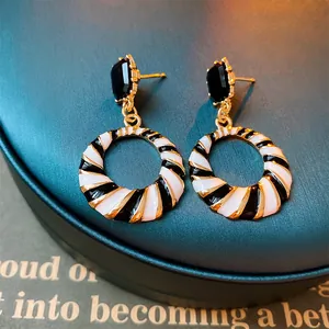 Macro view showing detail of geometric black and white hoop earrings with crystal studs