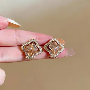 Elegant hollow flower stud earrings with champagne square crystal and pavé rhinestones.