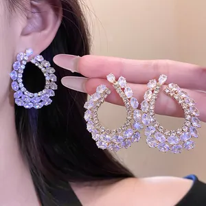 Gros plan sur des boucles d'oreilles créoles en forme de goutte en zircone étincelante