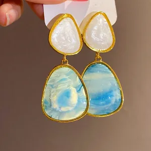 Elegant vintage resin drop earrings with white and blue marbled stones in gold frames