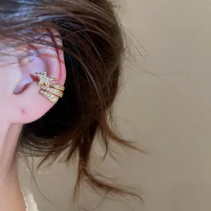 Detailed view of an elegant gold star zircon ear cuff on the upper ear cartilage area