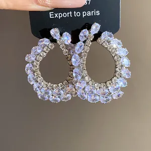 Détail de boucles d'oreilles élégantes en argent avec zircons violets éclatants
