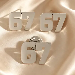 Dettaglio del set di orecchini a perno e spilla in acciaio inossidabile numero 67 sport