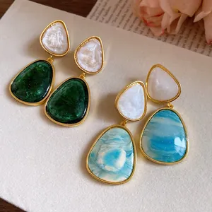 Detailed close-up view of vintage resin drop earrings featuring green and blue marble patterns.