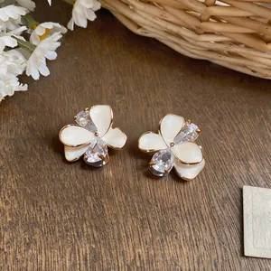 Close-up of elegant flower stud earrings with white petals and clear zircon crystals