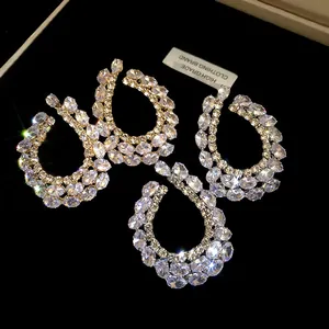 Gros plan détaillé de boucles d'oreilles goutte géométriques en zircon étincelant