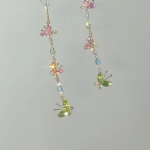 Eleganti orecchini a nappa lunga con farfalle in zircone colorato e montatura dorata.